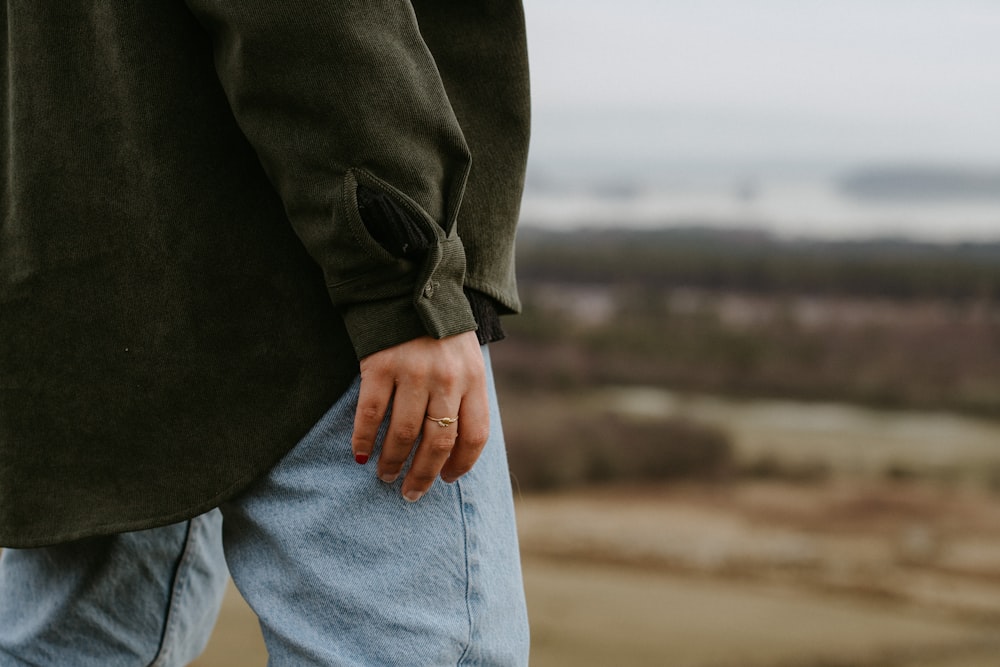 person in black coat and blue denim jeans