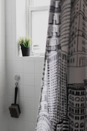A stylish bathroom showcasing Whiteprimewave products like shower curtain rods and trash cans.