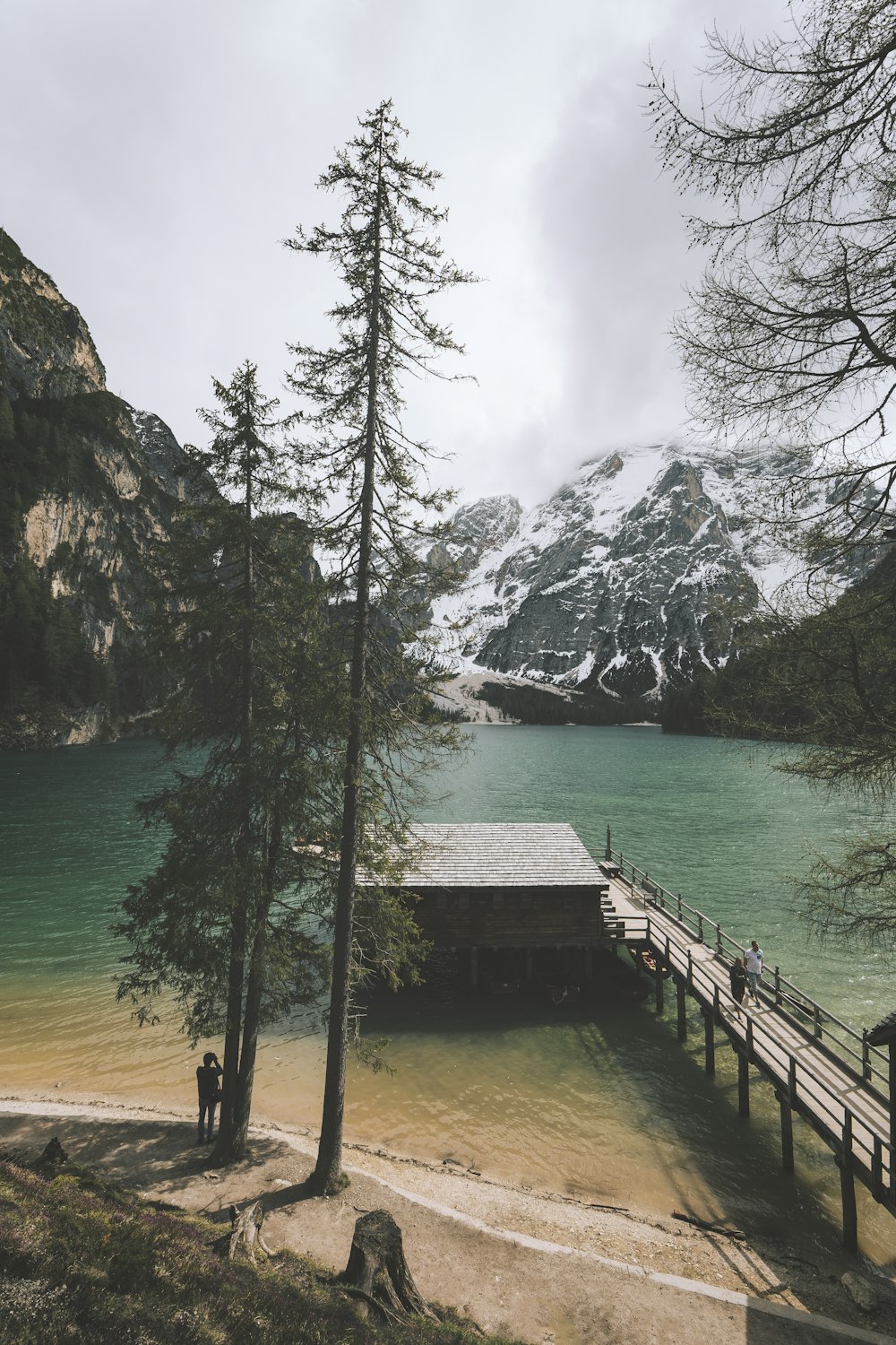 brown wooden dock on body of water near mountain during daytime