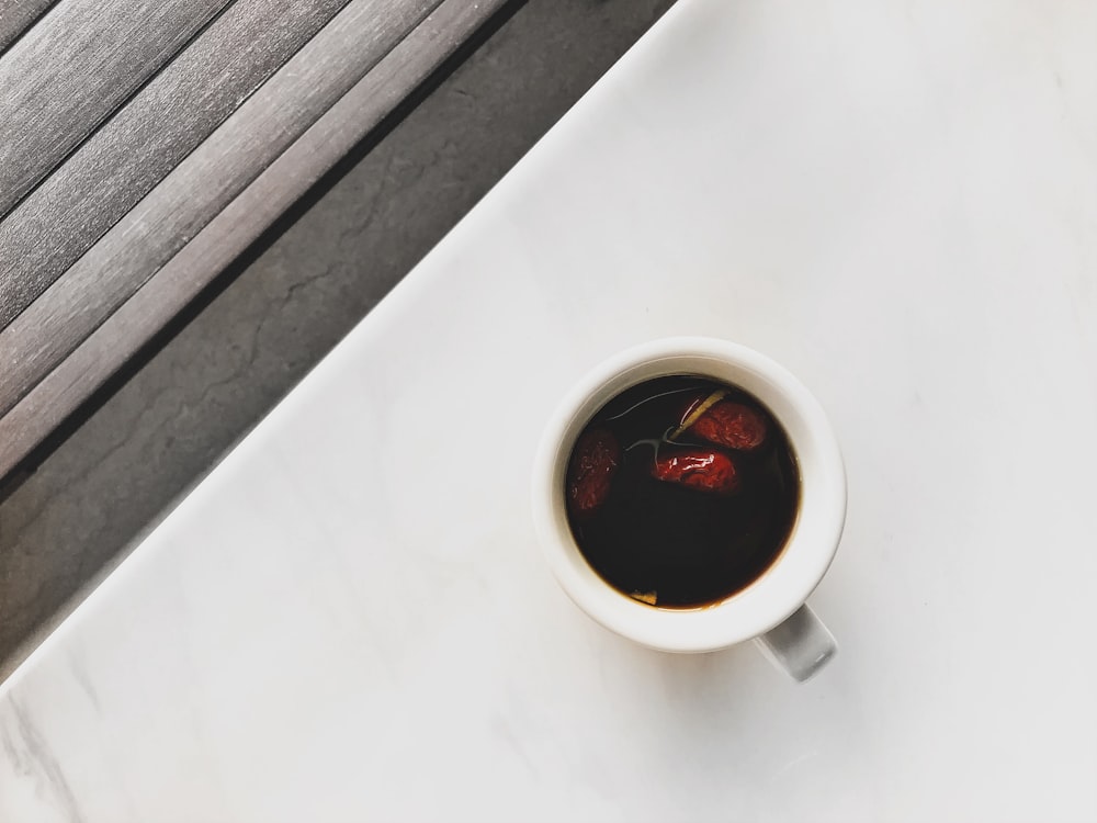 white ceramic mug with brown liquid inside