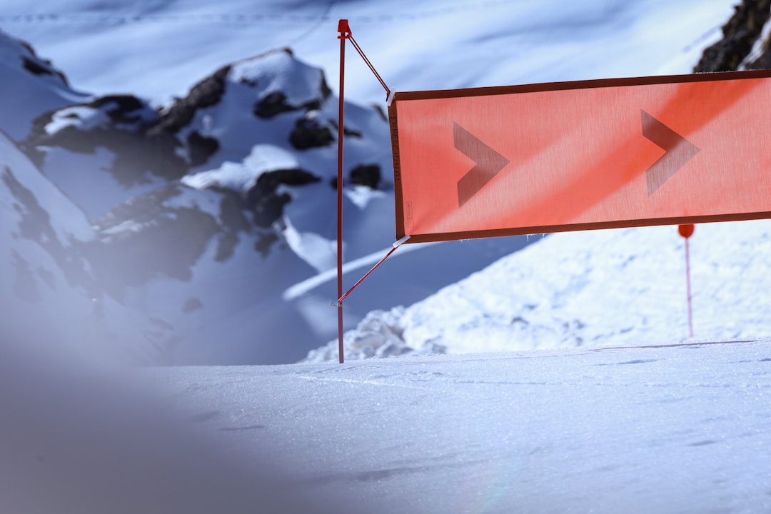red and white flag on snow covered ground during daytime