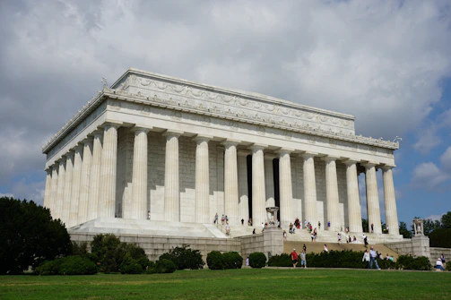 people in front of white concrete building during daytime