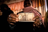 person holding 5 us dollar bill