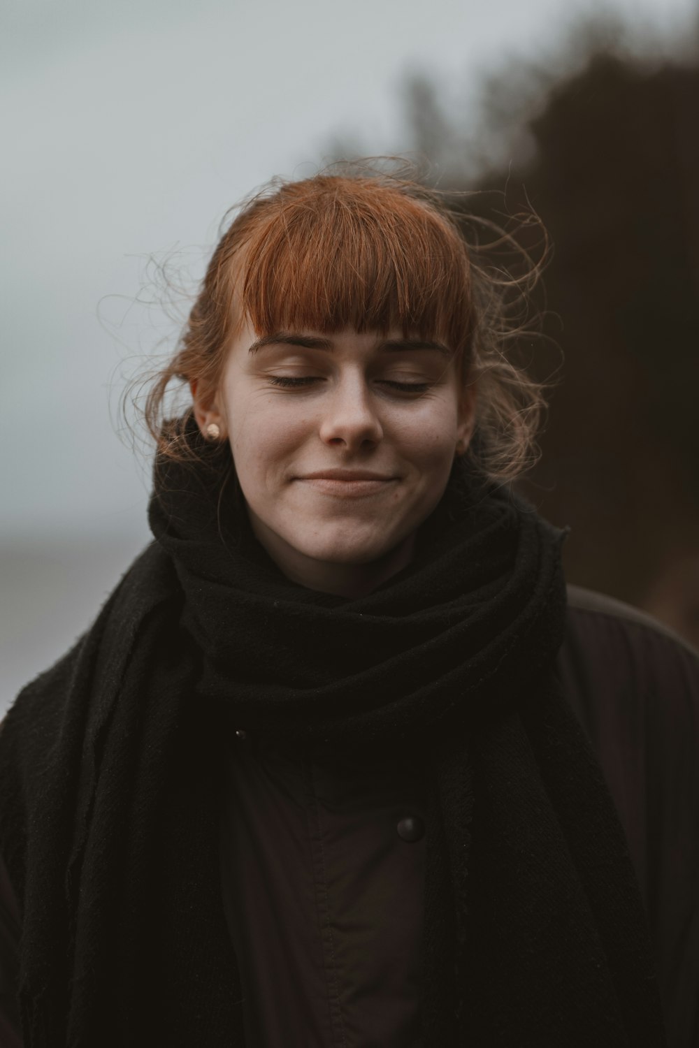 woman in black coat and brown scarf