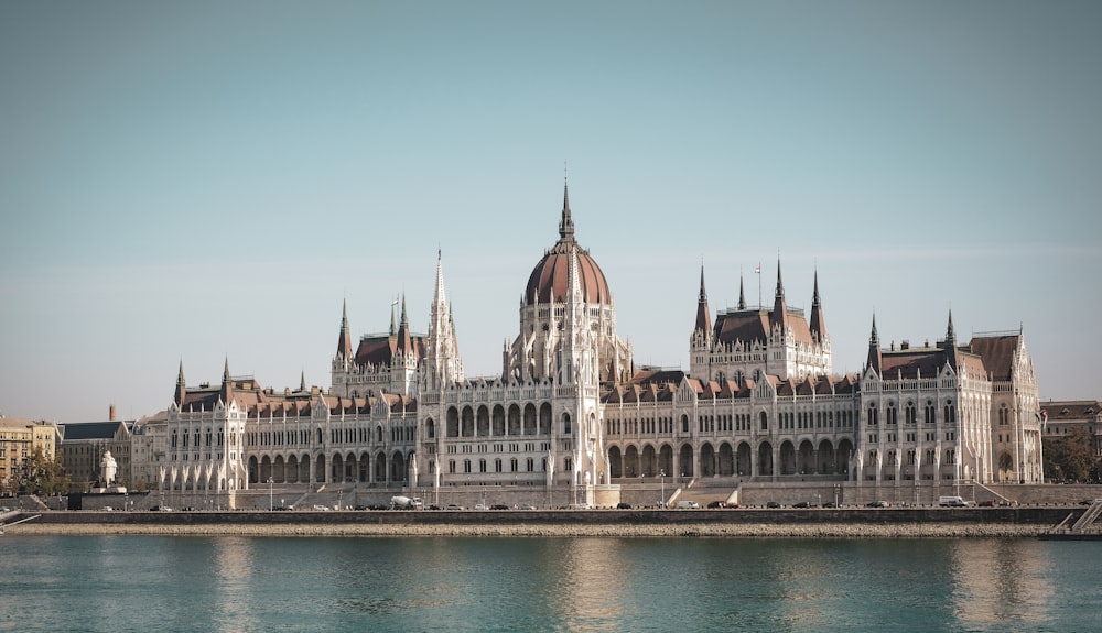 white and brown concrete building near body of water during daytime