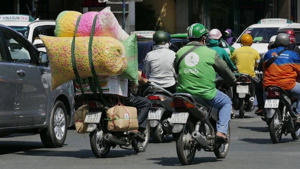 personnes portant un casque vert et jaune conduisant une moto pendant la journée