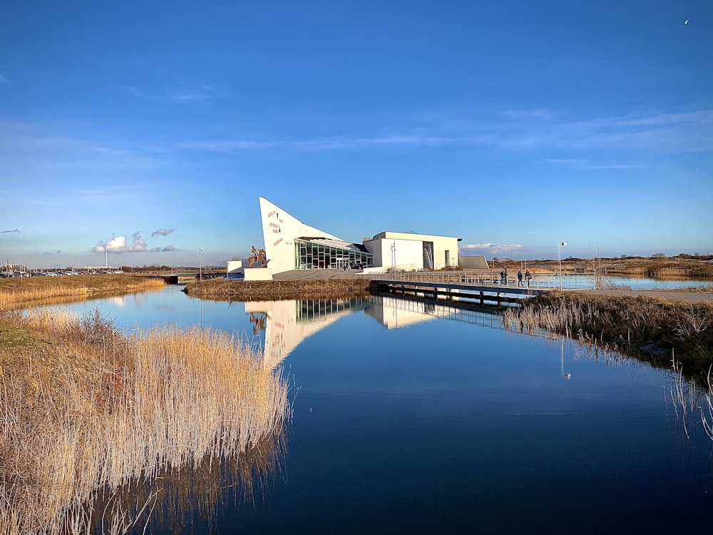 white and gray house near body of water under blue sky during daytime