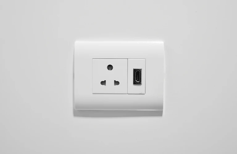 Modern white electrical socket with USB port installed in a home