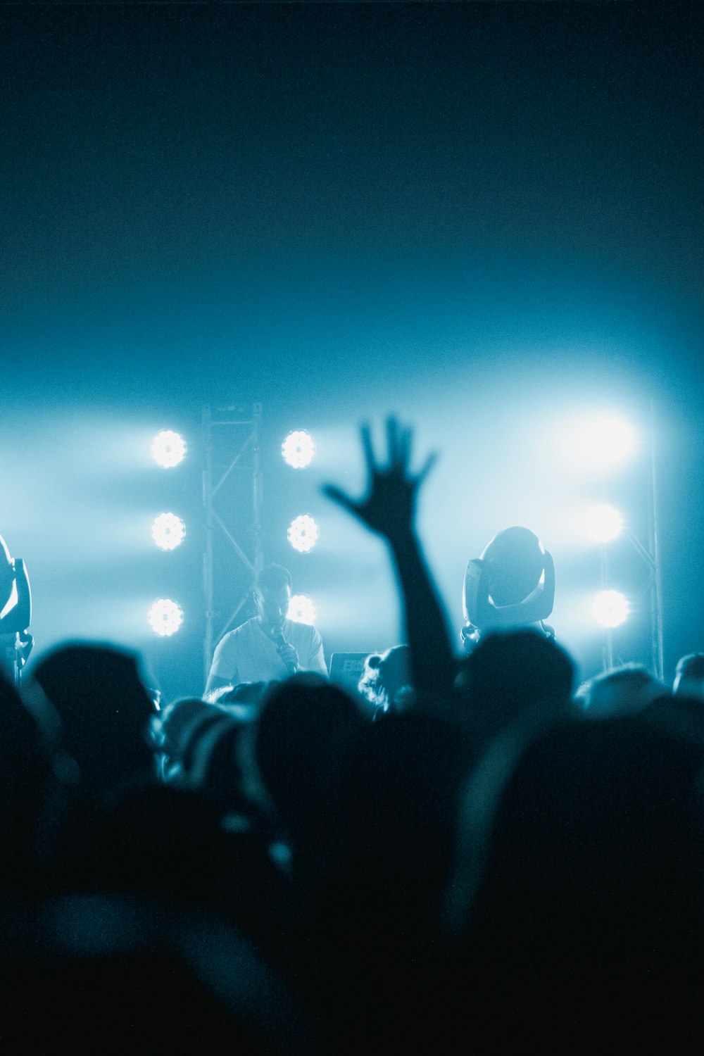 people raising their hands in front of stage