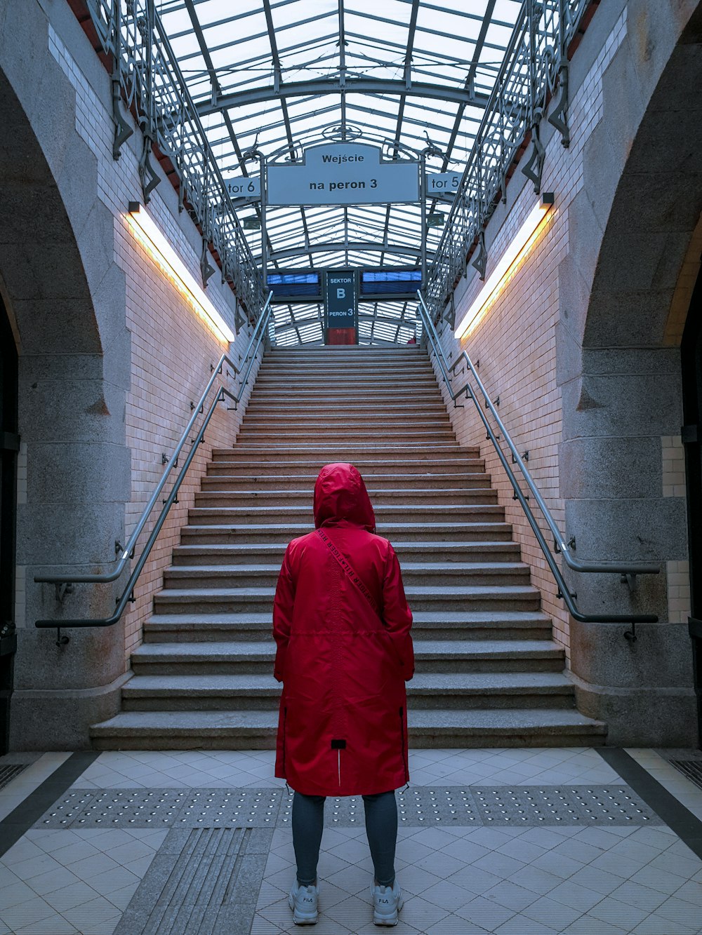 woman in red coat walking on the stairs