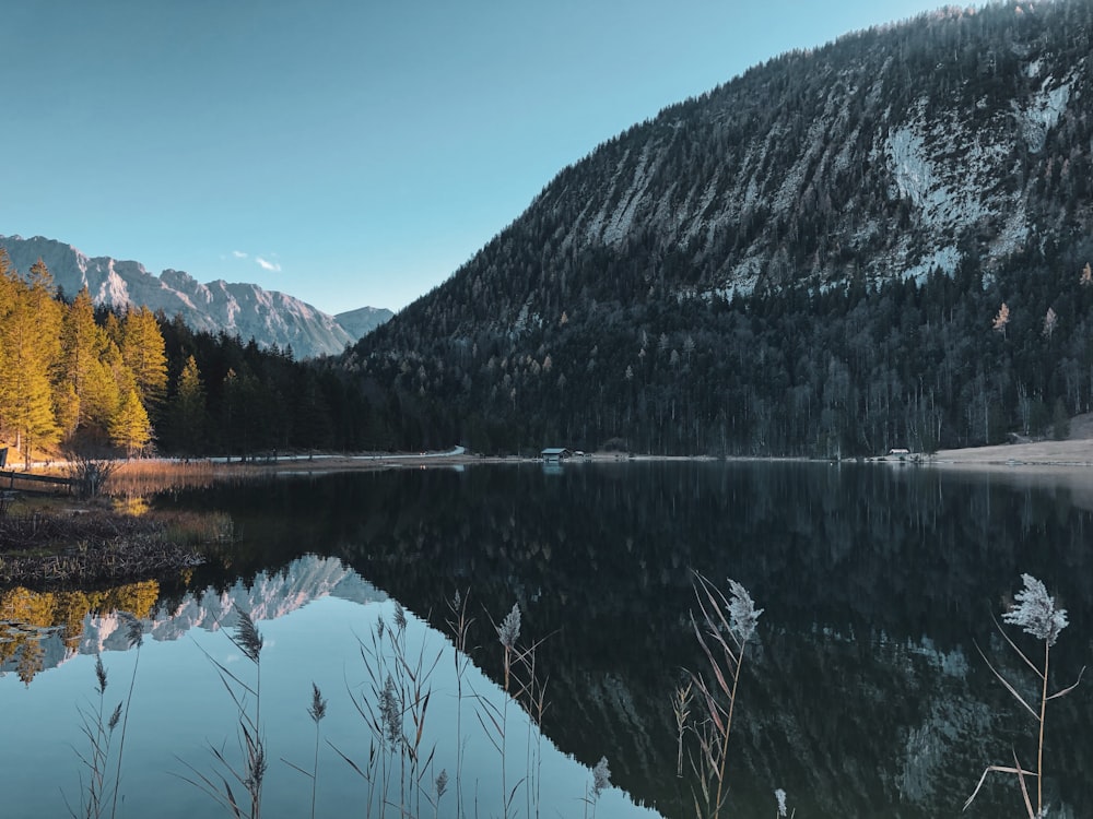 body of water near mountain during daytime