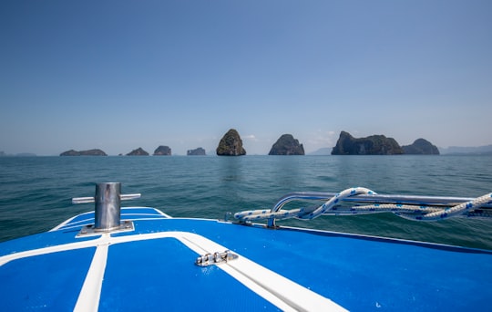 white and blue boat on sea during daytime in Ao Phang-nga National Park Thailand