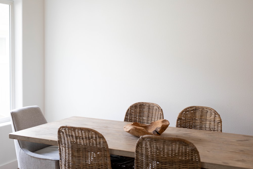 Chaise tissée marron à côté d’une table blanche