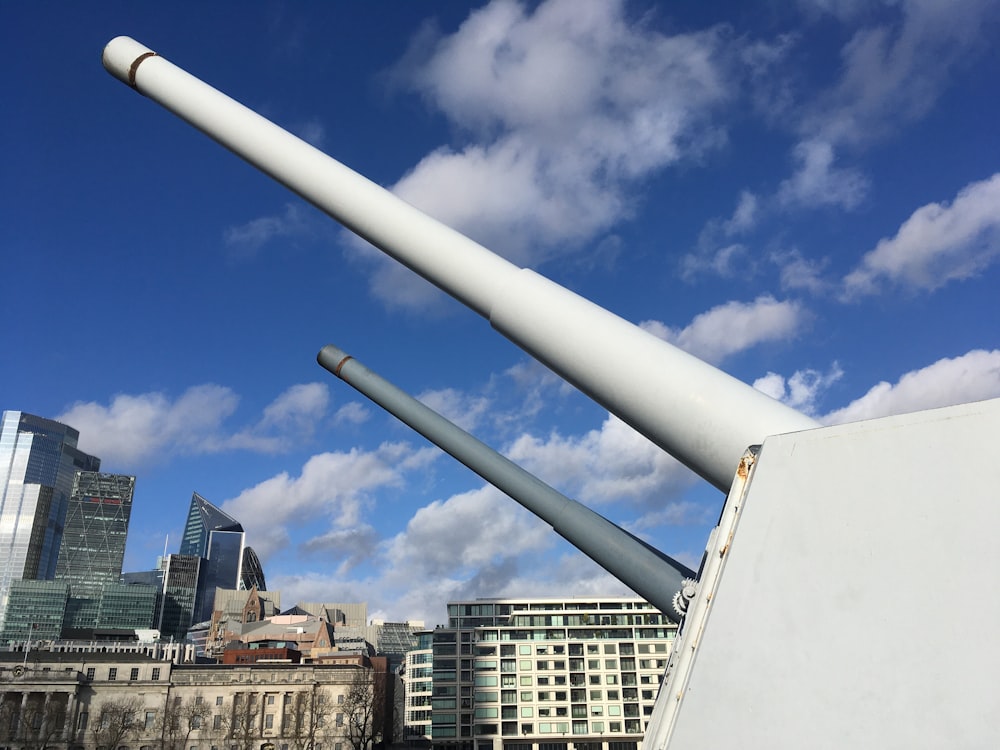 white metal pipe near high rise buildings during daytime