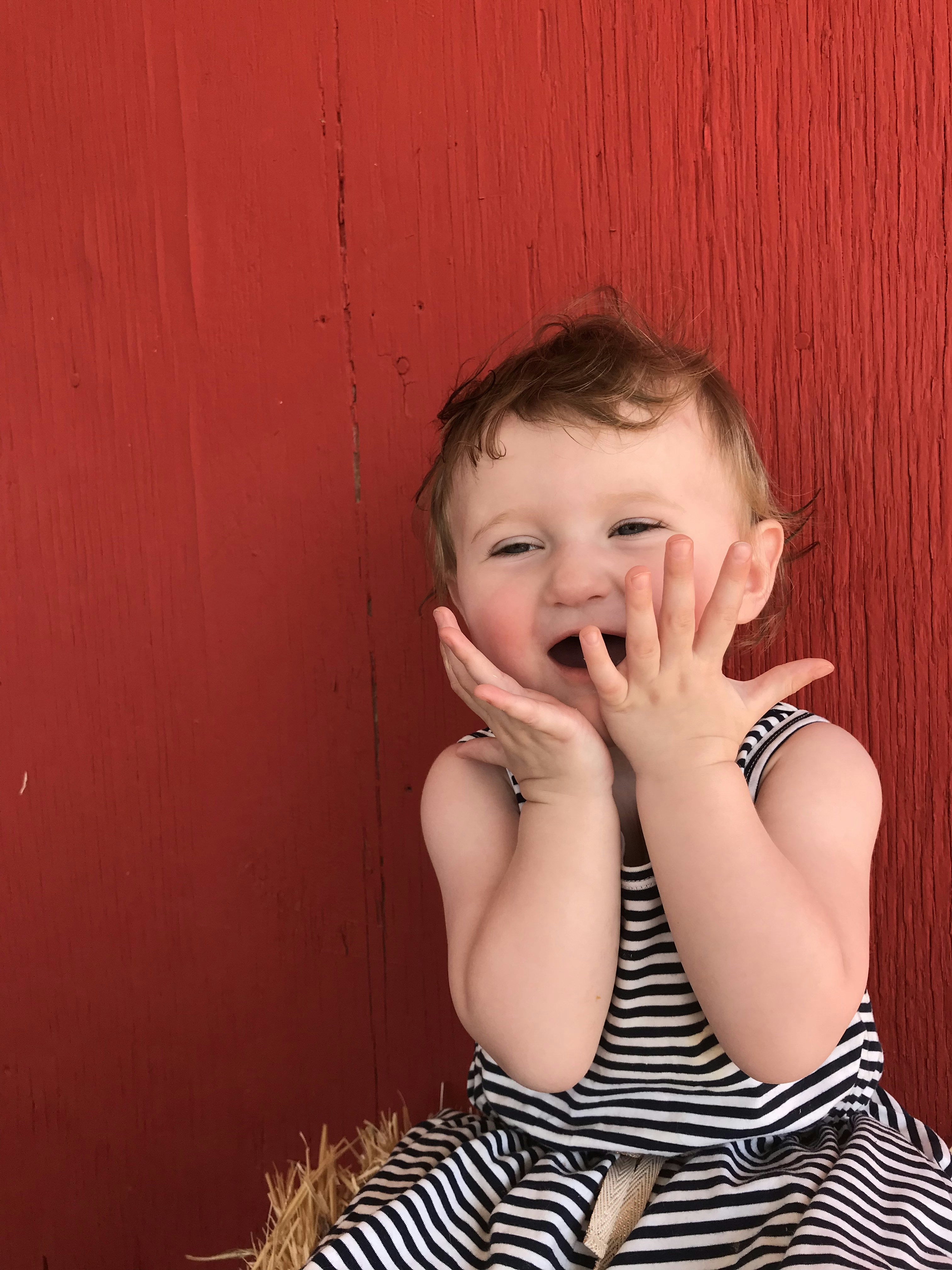 girl in black and white stripe tank top covering her mouth