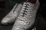 Finished pair of bespoke shoes made from snake skin, polished to a rich shine.