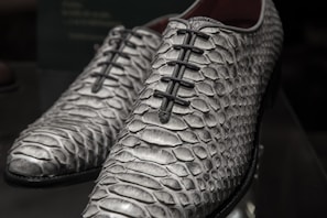 Finished pair of bespoke shoes made from snake skin, polished to a rich shine.