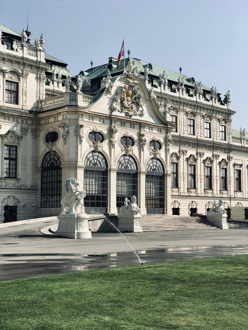 Weißes Betongebäude mit Statue davor