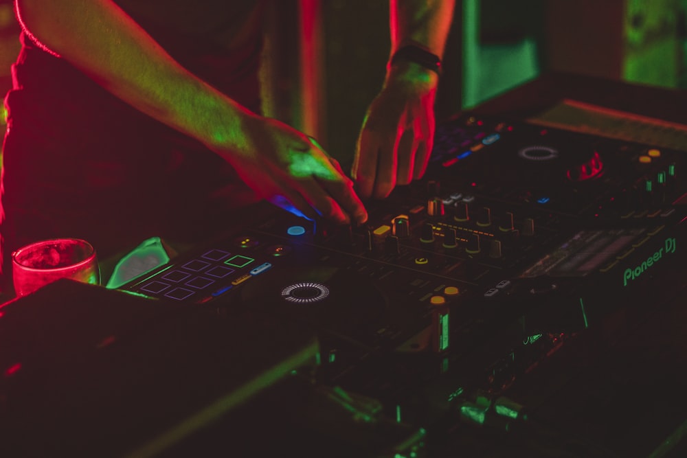 person playing dj mixer in dark room