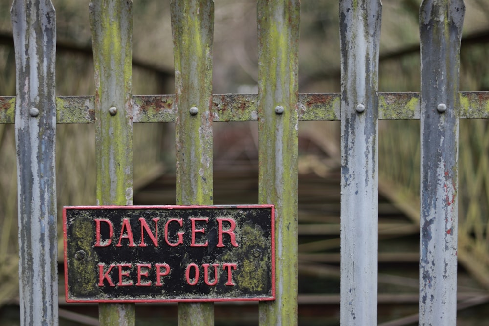 brown wooden fence with red and black wooden signage