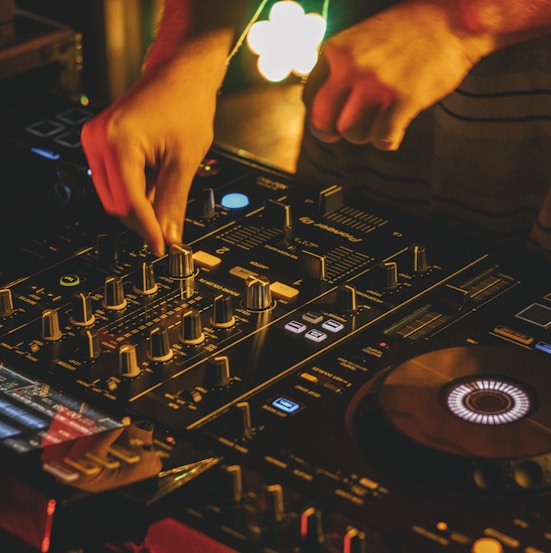 person playing dj mixer with vinyl record