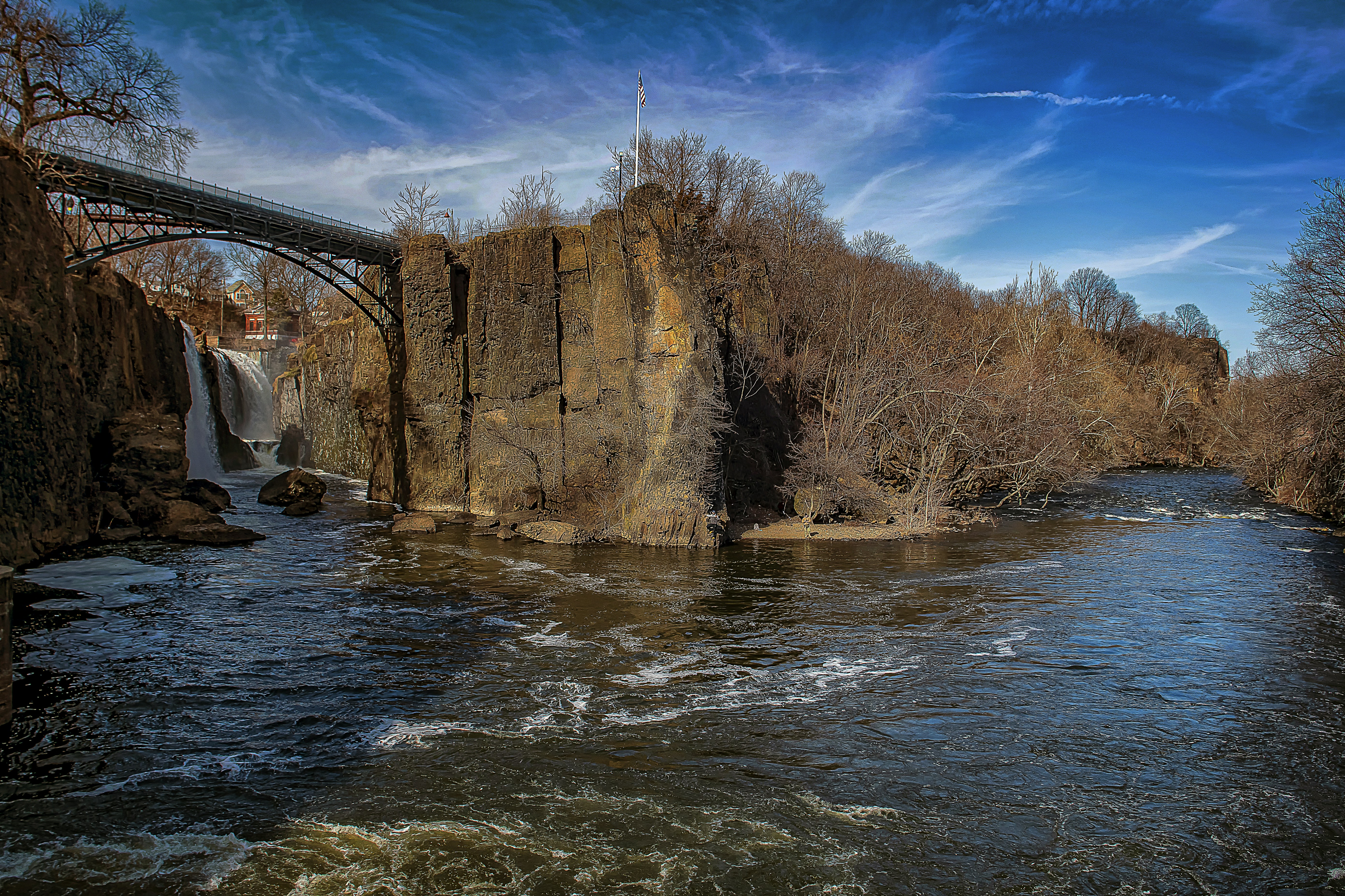 brown concrete building near river under blue sky during daytime