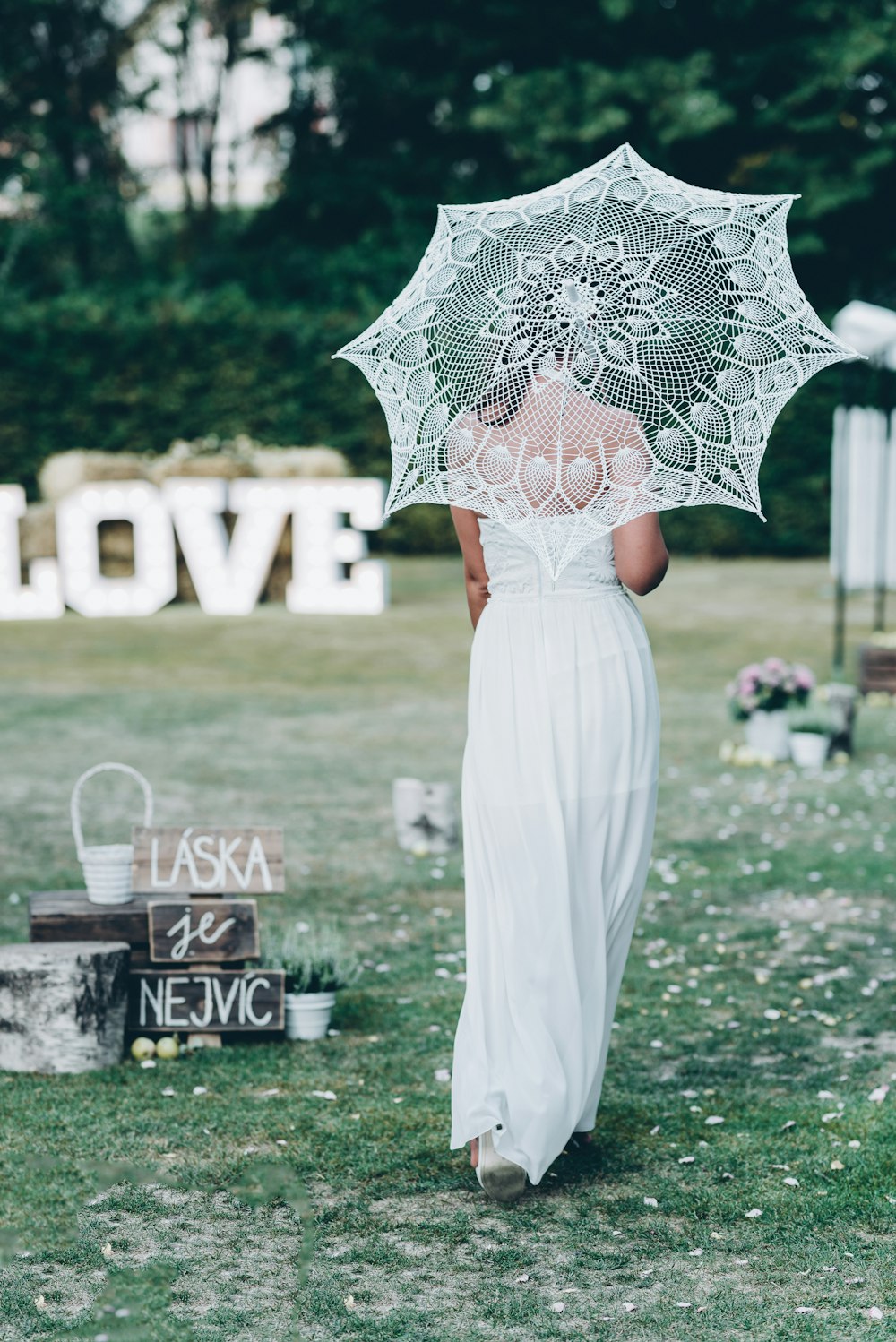 a woman in a white dress holding an umbrella