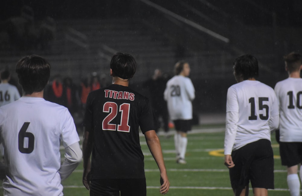 man in black and red jersey shirt standing beside man in white long sleeve shirt