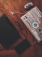 black framed eyeglasses beside white earbuds