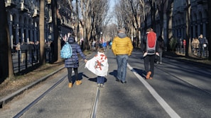 A family walking along the tree-lined streets of U.S. Society, enjoying the peaceful neighborhood.