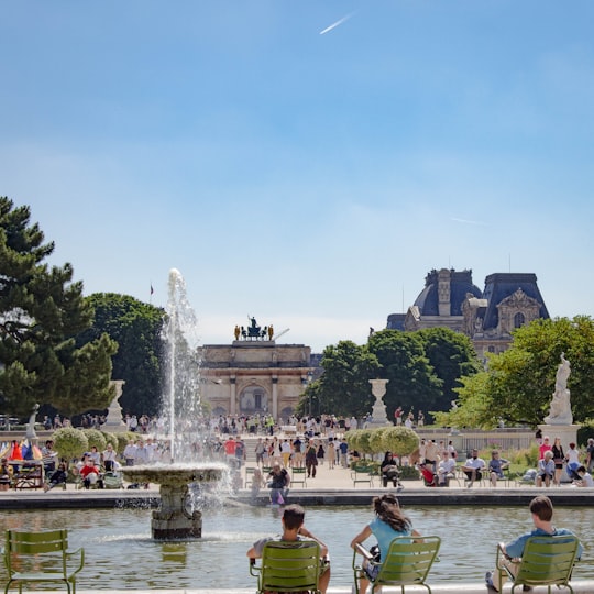 people in green shirt riding on boat on water fountain during daytime in Tuileries Garden France