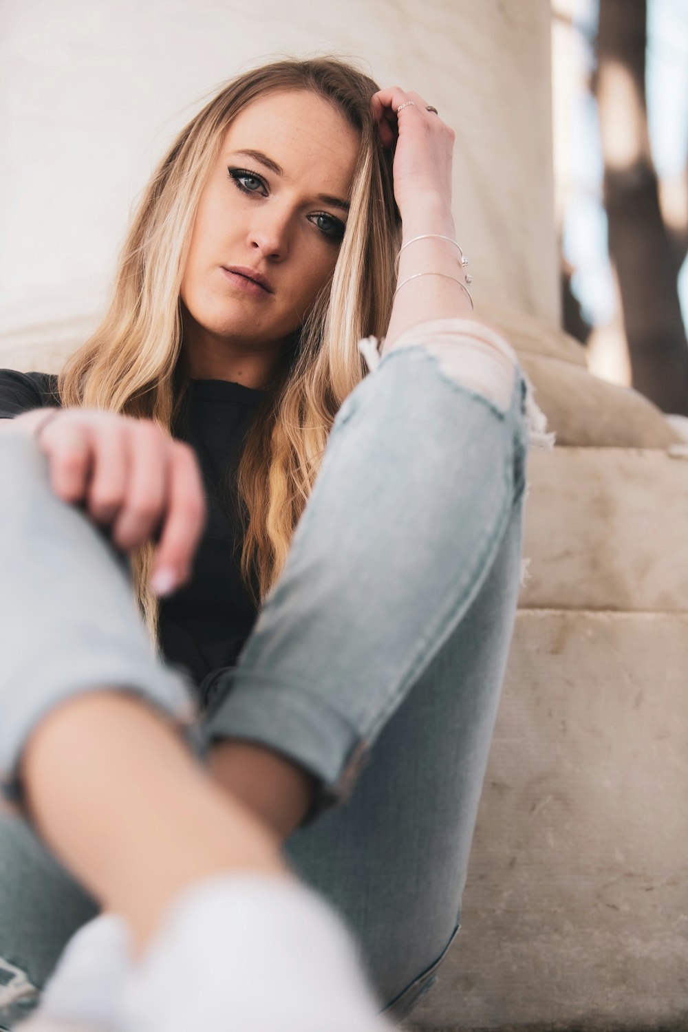 Femme en jean bleu assis sur un banc en béton brun