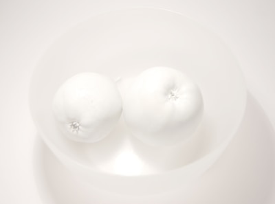 A minimalist bowl filled with crisp dried apple rings on a soft beige background.
