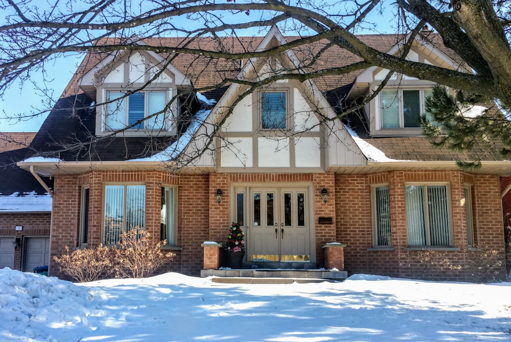 brown and white concrete house near bare trees during daytime