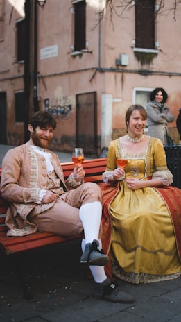 man and woman sitting on brown wooden bench