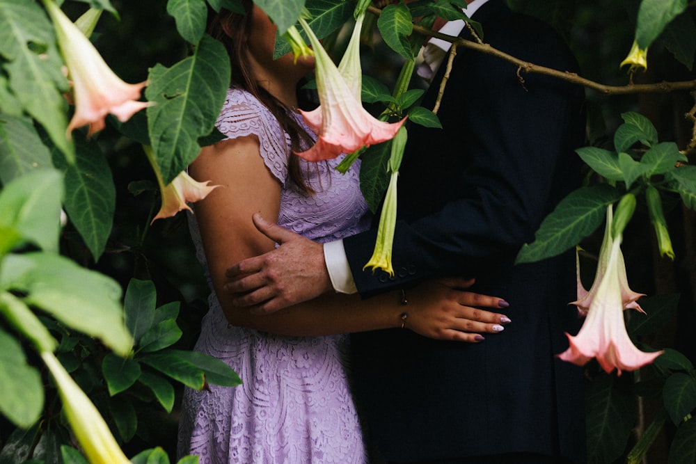 woman in purple dress holding pink flower