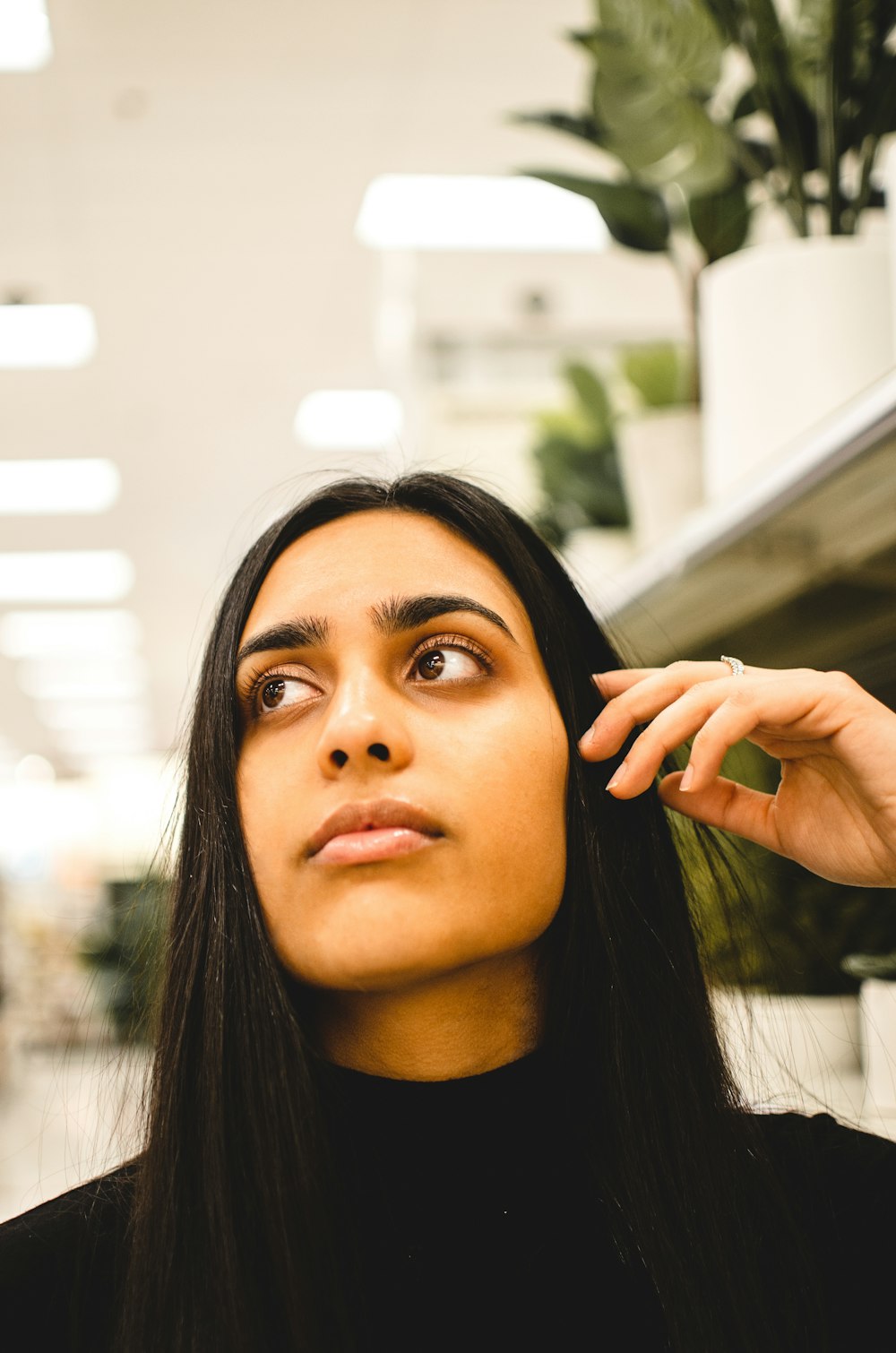 woman in black shirt holding her face