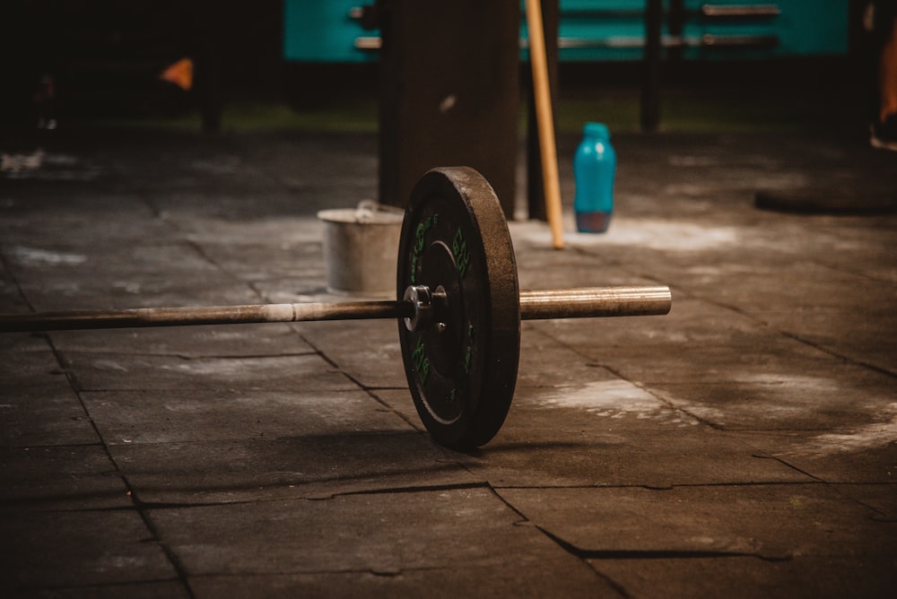 black and blue dumbbell on brown wooden floor