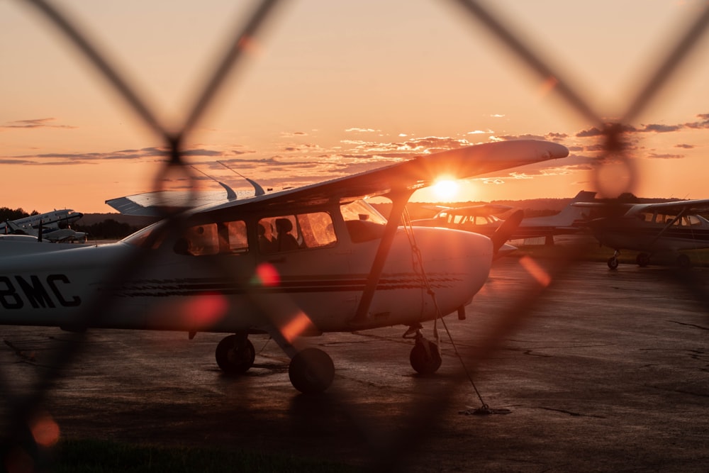 white and orange passenger plane on field during sunset