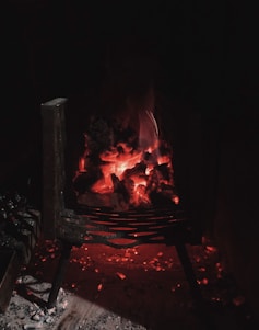A glowing charcoal fire with embers radiating warmth in a dark setting.