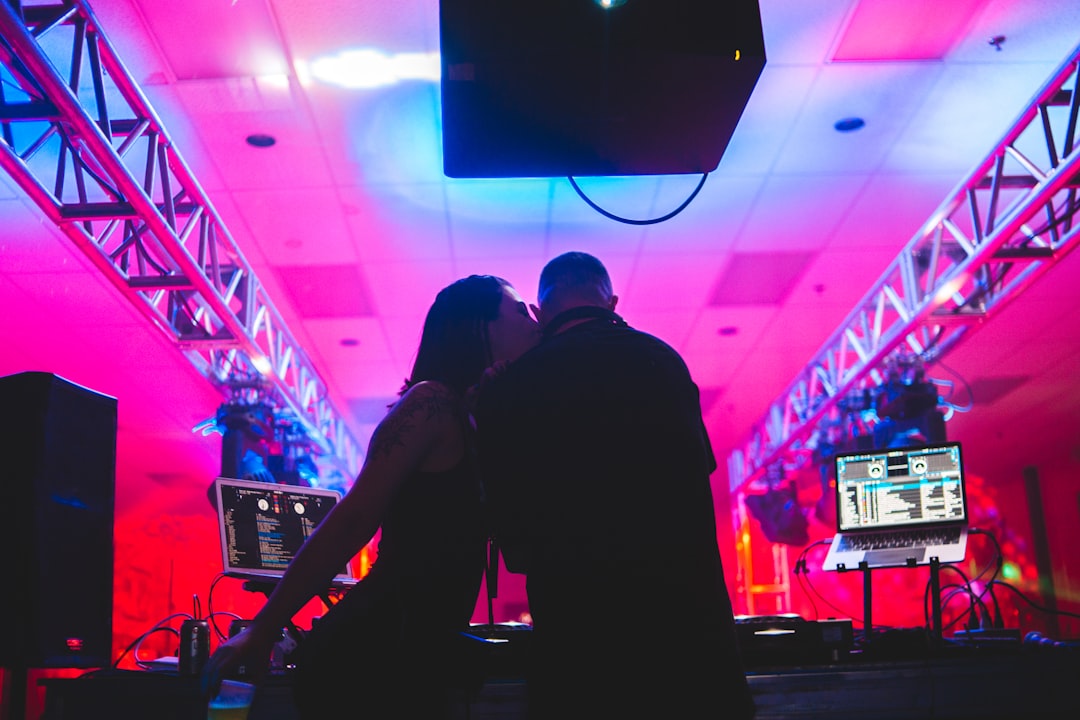 man in black suit standing in front of dj mixer