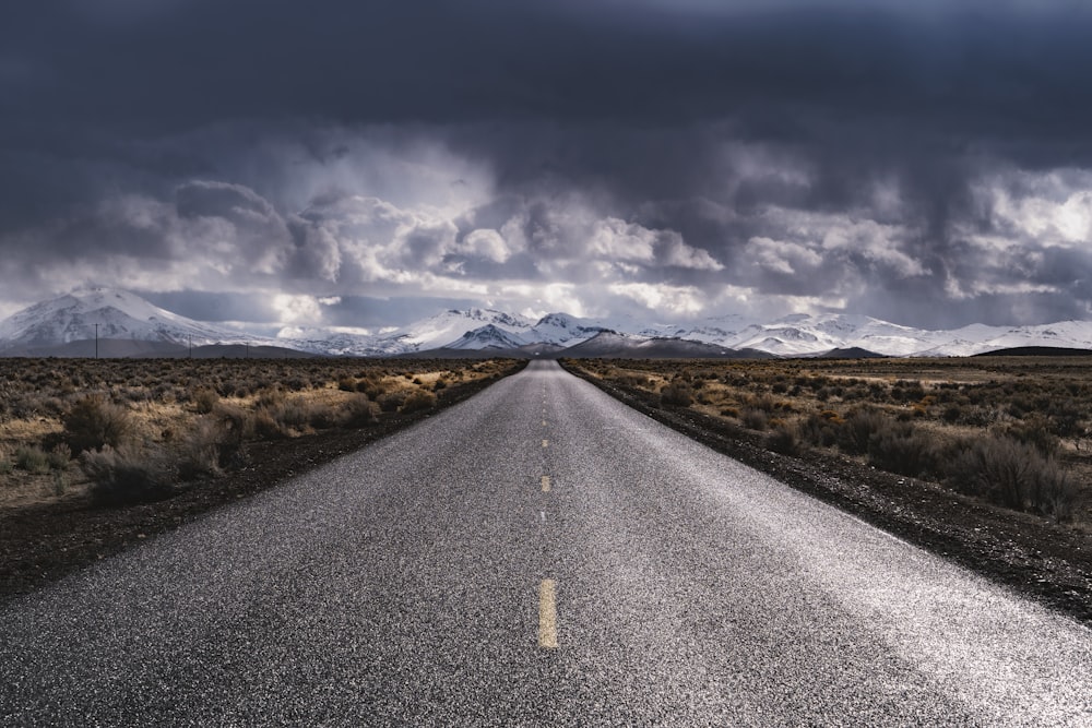 camino de asfalto gris bajo cielo nublado gris