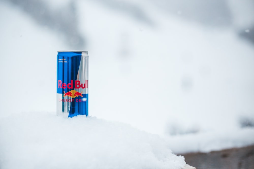 blue and red can on snow covered ground