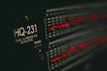 A close-up of a piece of audio equipment, specifically an equalizer labeled HQ-231 with glowing red LED indicators. The surrounding area is dark, focusing attention on the illuminated details of the device.