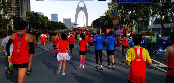 Runners crossing the finish line in a vibrant city marathon with cheering crowds.