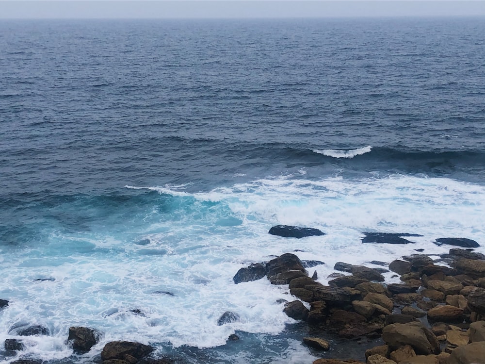 ocean waves crashing on rocks during daytime