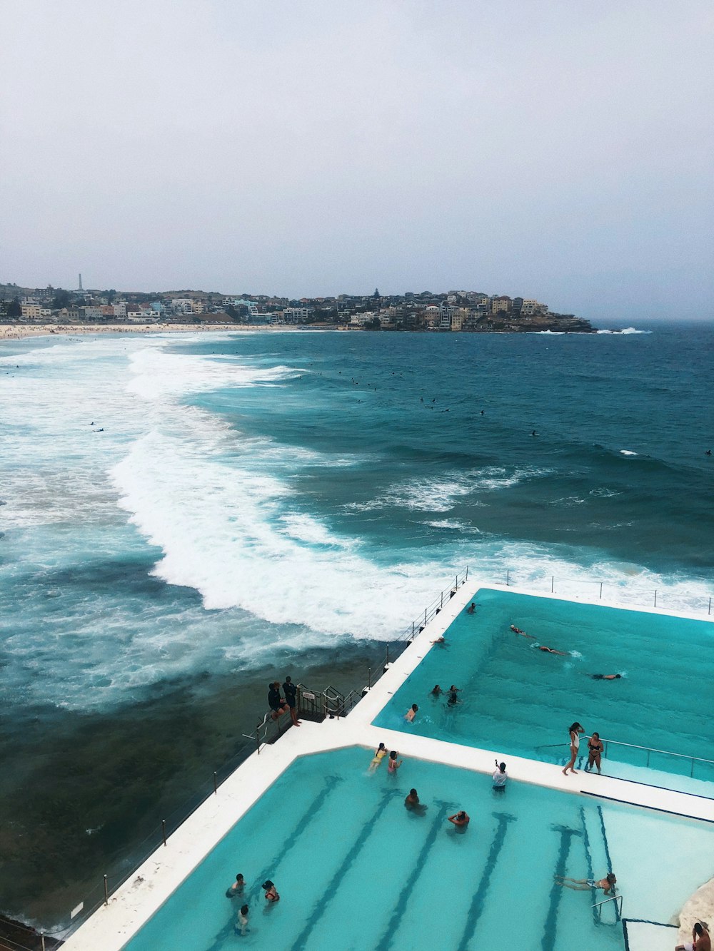 people swimming on pool near beach during daytime