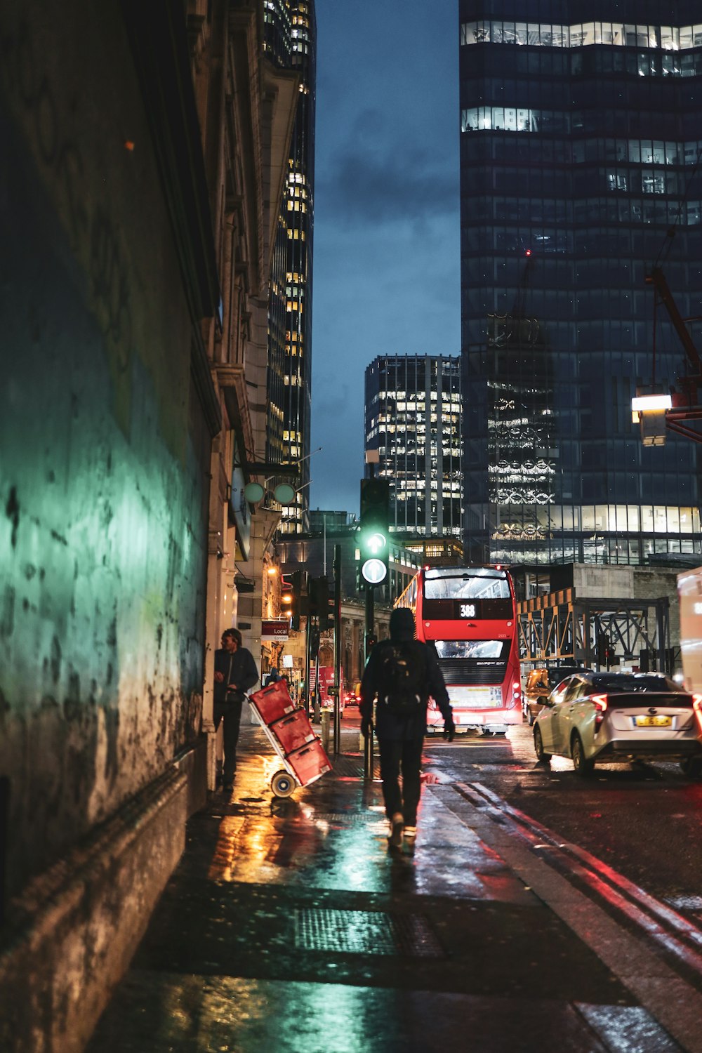 man in black jacket walking on sidewalk during night time