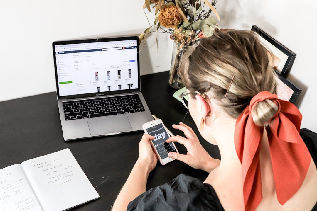 woman in orange shirt using iphone to process payments