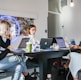 3 women sitting on chair in front of table with laptop computers